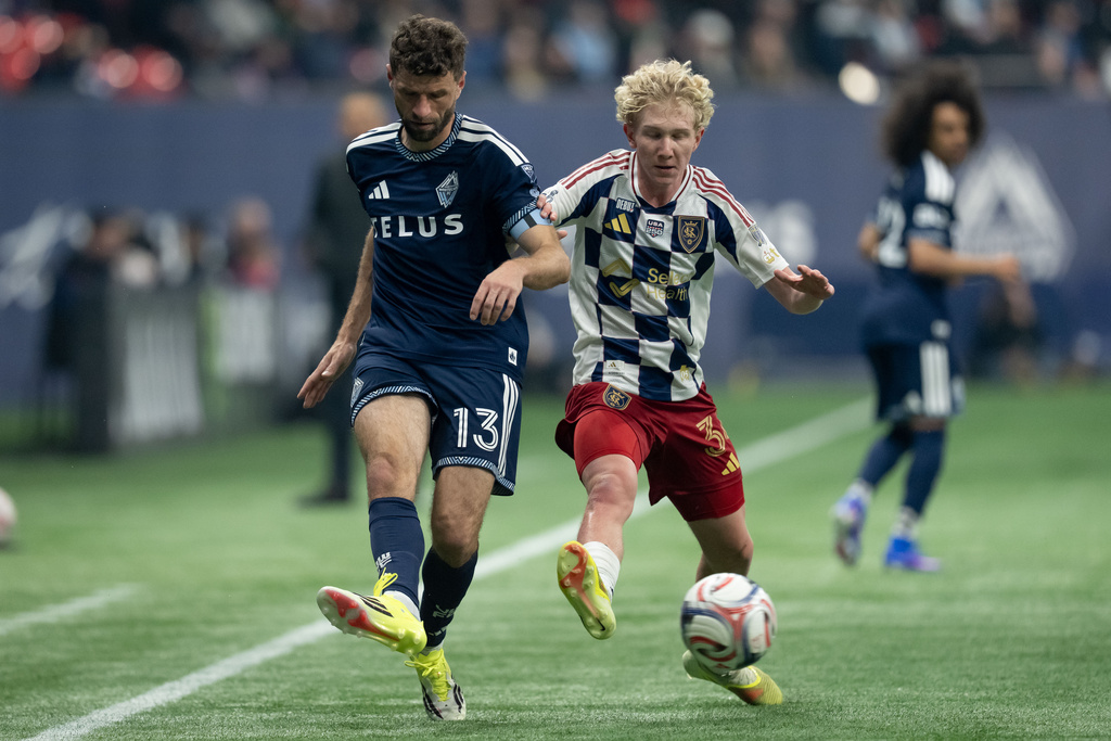 Vancouver Whitecaps' Thomas Muller (13) and Real Salt Lake's Luca Moisa (34) vie for the ball during the first half of an MLS soccer match in Vancouver, on Saturday, Feb. 21, 2026. (Ethan Cairns/The Canadian Press via AP)