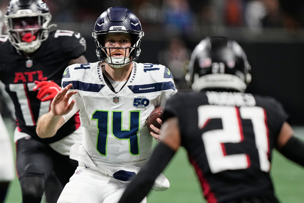 Seattle Seahawks quarterback Sam Darnold (14) runs the ball against Atlanta Falcons cornerback Mike Hughes (21) during the second half of an NFL football game, Sunday, Dec. 7, 2025, in Atlanta. (AP Photo/Brynn Anderson)