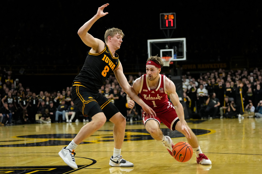 Nebraska guard Sam Hoiberg (1) drives to the basket past Iowa forward Cooper Koch (8) during the first half of an NCAA college basketball game, Tuesday, Feb. 17, 2026, in Iowa City, Iowa. (AP Photo/Charlie Neibergall)