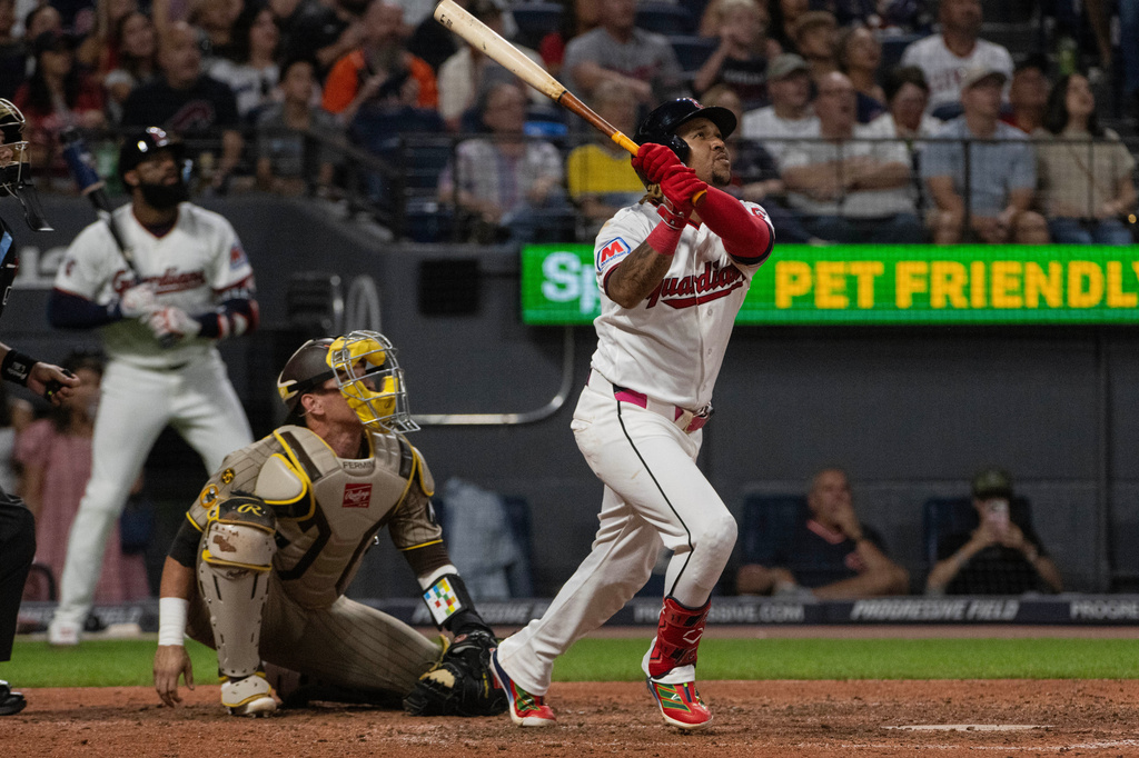 Cleveland Guardians' Jose Ramirez watches his sacrifice fly with San Diego Padres' Freddy Fermin during the fifth inning of a baseball game, Saturday, Aug. 15, 2026, in Cleveland. (AP Photo/Phil Long)