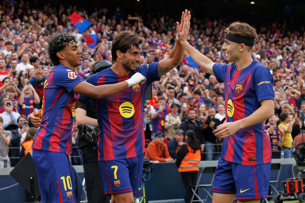 Barcelona's Ferran Torres, centre, celebrates after scoring his side's second goal with Lamine Yamal, left, and Fermin Lopez during the Spanish La Liga soccer match between Barcelona and Espanyol in Barcelona, Spain, Saturday, April 11, 2026. (AP Photo/Joan Monfort)