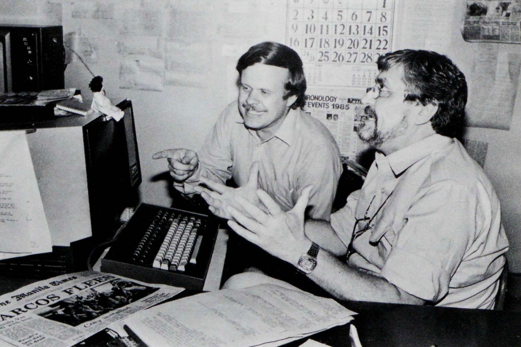 In this undated photo published in The AP World in 1986, Manila bureau chief David Briscoe, left, and Asia news director Richard Pyle discuss a story. (AP Photo)