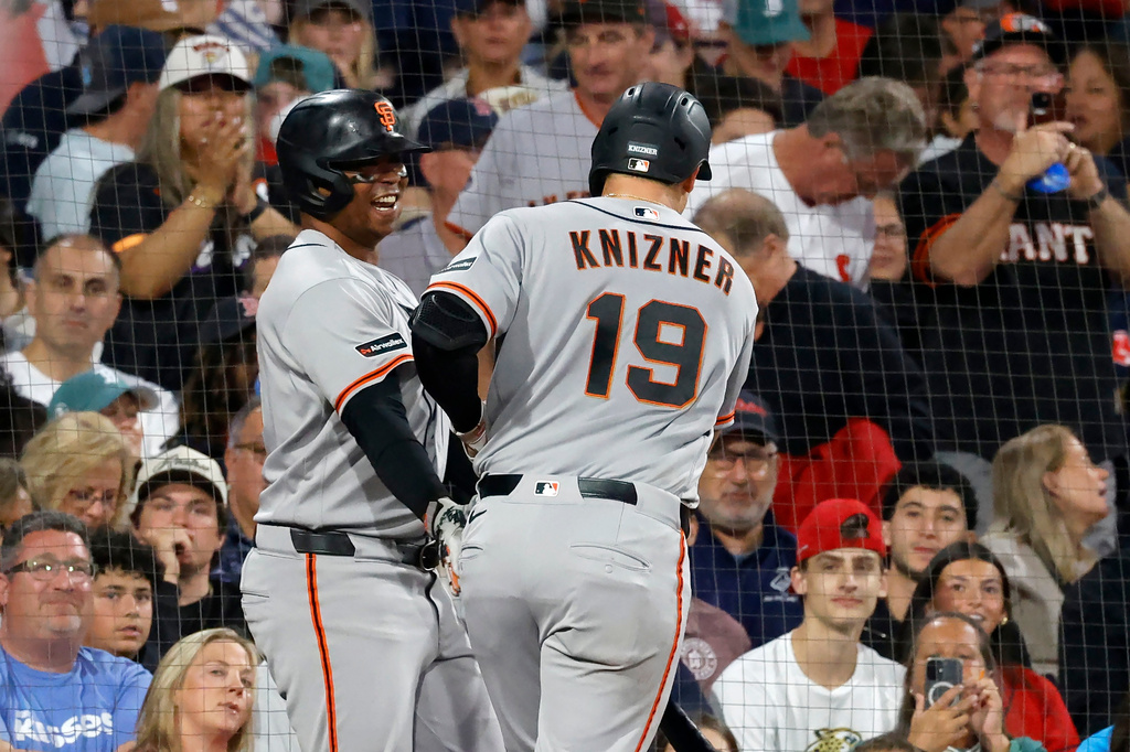 San Francisco Giants' Andrew Knizner (19) is congratulated by teammate Rafael Devers, left, after hitting a home run during the third inning of a baseball game against the Boston Red Sox, Saturday, Aug. 22, 2026, in Boston. (AP Photo/Mary Schwalm)