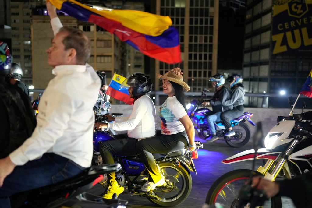 Opposition leaders María Oropeza and Juan Pablo Guanipa, left, ride motorbikes through Caracas, Venezuela, after their release from custody, Sunday, Feb. 8, 2026. (AP Photo/Ariana Cubillos)