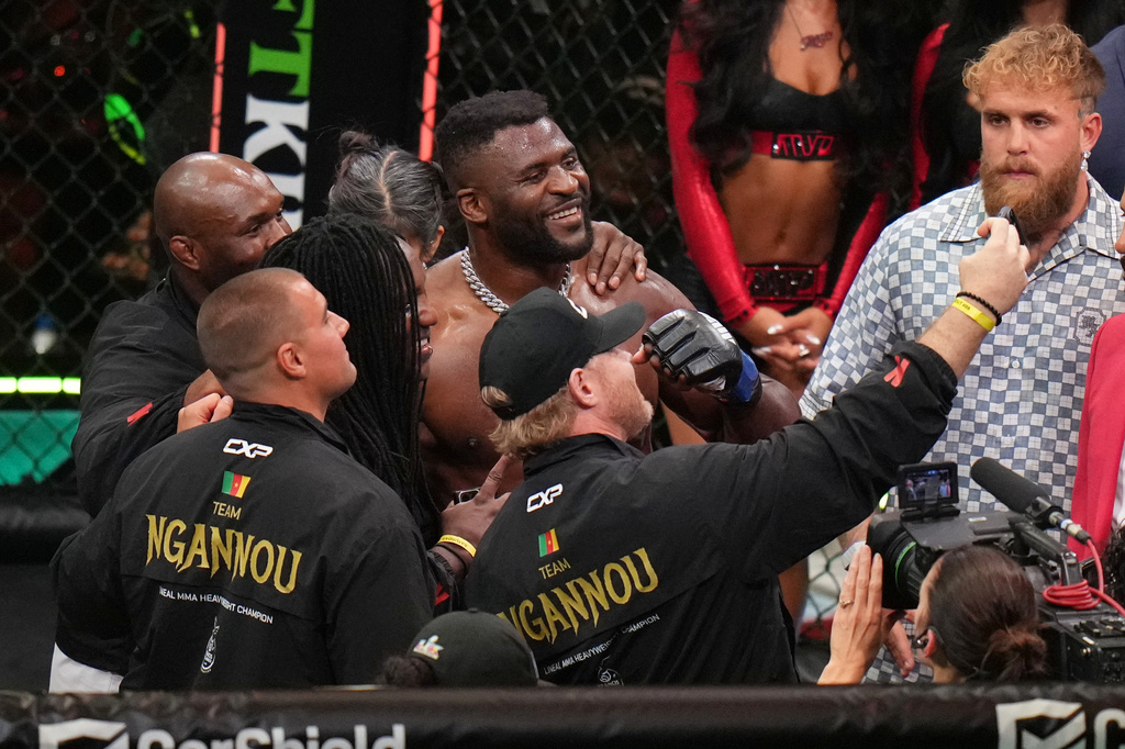 Francis Ngannou, of Cameroon, center, celebrates after defeating Philipe Lins, of Brazil, in their heavyweight mixed martial arts fight as Jake Paul, right, looks on, Saturday, May 16, 2026, in Inglewood, Calif. (AP Photo/Jae C. Hong )