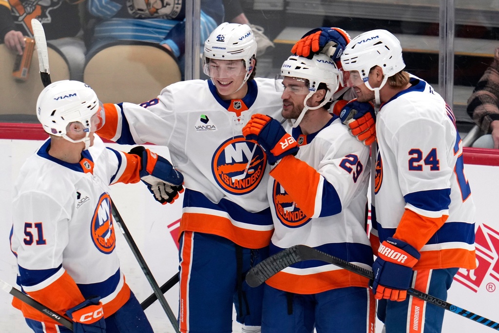 New York Islanders' Jonathan Drouin (29) celebrates after his goal with Matthew Schaefer (48), Scott Mayfield (24) and Emil Heineman (51) during the first period of an NHL hockey game against the Pittsburgh Penguins in Pittsburgh, Thursday, Oct. 9, 2025. (AP Photo/Gene J. Puskar)
