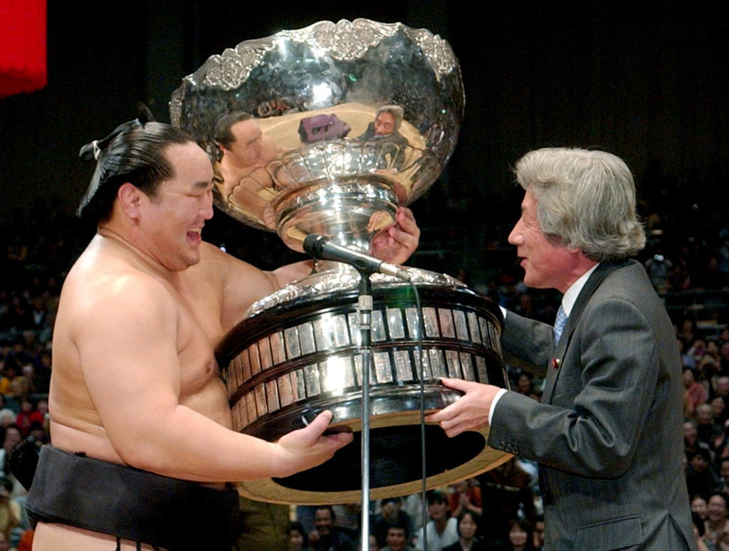 FILE - Grand Champion Asashoryu, left, is presented his champion trophy from Prime Minister Junichiro Koizumi following his victory at the Kyushu Grand Sumo Tournament in Fukuoka, southern Japan, on Nov. 27, 2005. (Kyodo News via AP, File)