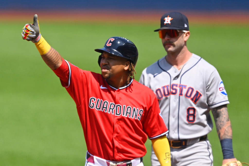Cleveland Guardians' Jose Ramirez, left, celebrates his single beside Houston Astros first baseman Christian Walker (8) in the first inning of a baseball game in Cleveland, Wednesday, April 22, 2026. (AP Photo/David Richard)