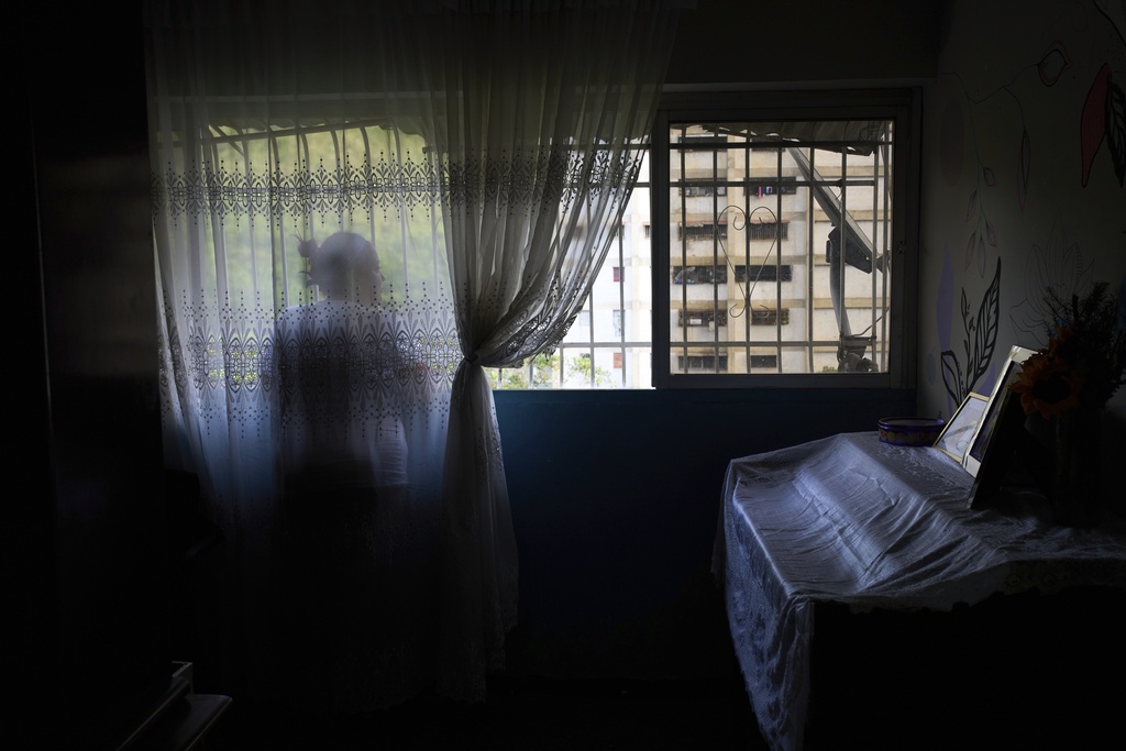 Syntia Caceres looks out the window of her home while talking about her four-year-old granddaughter Aurore, who was placed in foster care in the U.S. state of Georgia after her son was detained in July, in Caracas, Venezuela, Thursday, 4, 2025. (AP Photo/Ariana Cubillos)