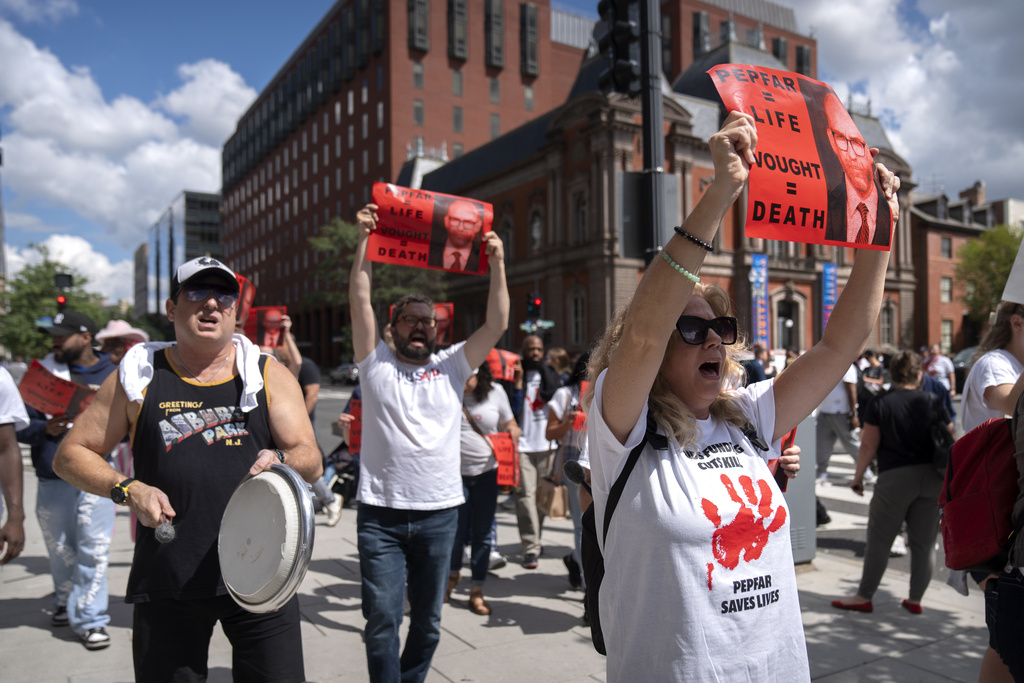 Demonstrators protesting against the Trump administration's withholding of federal funds for the PEPFAR program to combat HIV/AIDS march near the White House, Tuesday, Sept. 2, 2025, in Washington. (AP Photo/Mark Schiefelbein)