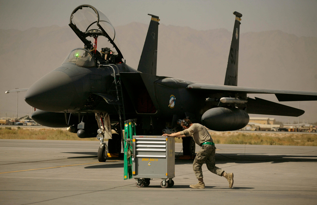 FILE - A U.S. Air Force airman pushes a cart past an F-15E Strike Eagle at Bagram Air Field in Afghanistan on Oct. 17, 2009. (AP Photo/Maya Alleruzzo, File)