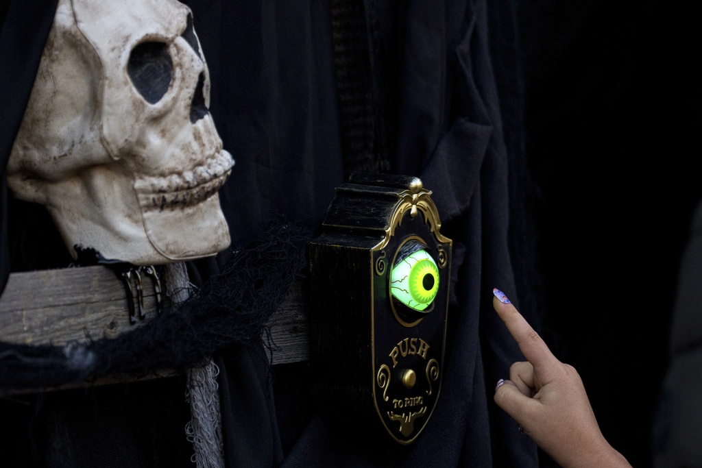 A girl rings the doorbell of a horror-themed room at the West Side Hallo Fest, the country's largest Halloween festival in Bucharest, Romania, Friday, Oct. 24, 2025. (AP Photo/Andreea Alexandru)