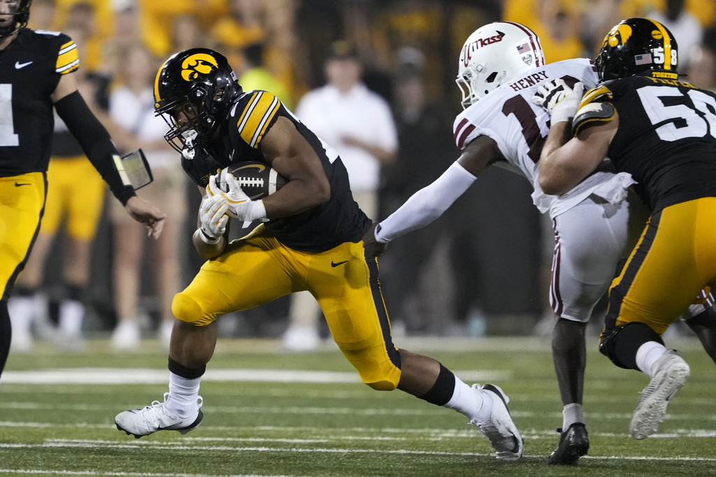 Iowa running back Xavier Williams runs from Massachusetts linebacker Rashad Henry, right, during the first half of an NCAA college football game, Saturday, Sept. 13, 2025, in Iowa City, Iowa. (AP Photo/Charlie Neibergall)