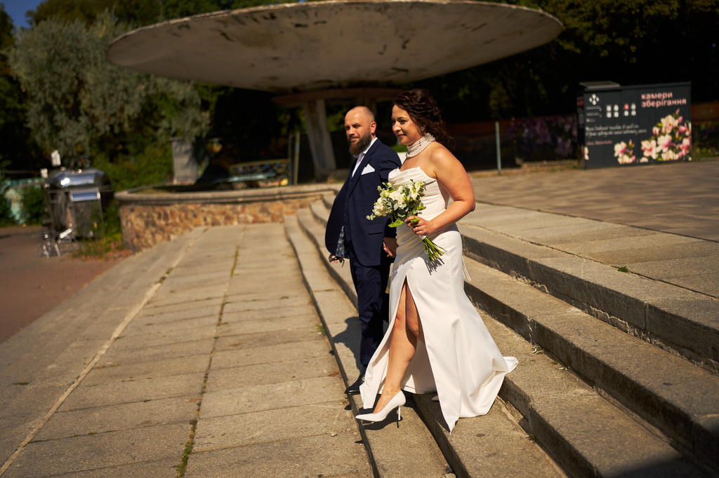 Newlyweds Iryna Baranova, right, and Evhen Mytsyk leave after their wedding portrait session at the botanical gardens, on their wedding day in Kyiv, Wednesday, Sept. 2, 2026. (AP Photo/Francisco Seco)