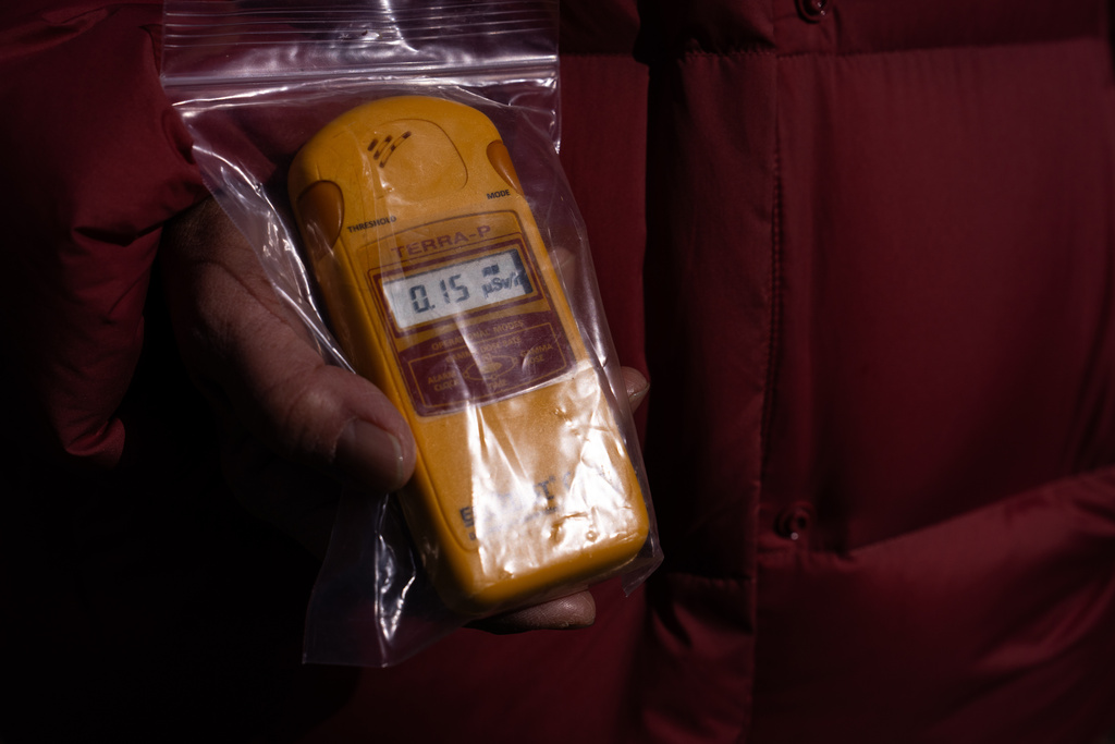 Tomoko Kobayashi shows a radiation monitor reading after measuring radiation during an interview in Odaka, Friday, Feb. 13, 2026. (AP Photo/Louise Delmotte)