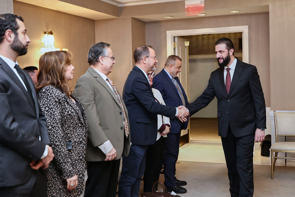 In this photo, released by the Syrian Presidency Press Office, Syrian President Ahmad al-Sharaa, right, meets with representatives of Syrian American organizations in Washington, Saturday, Nov. 8, 2025. (Syrian Presidency Press Office via AP)