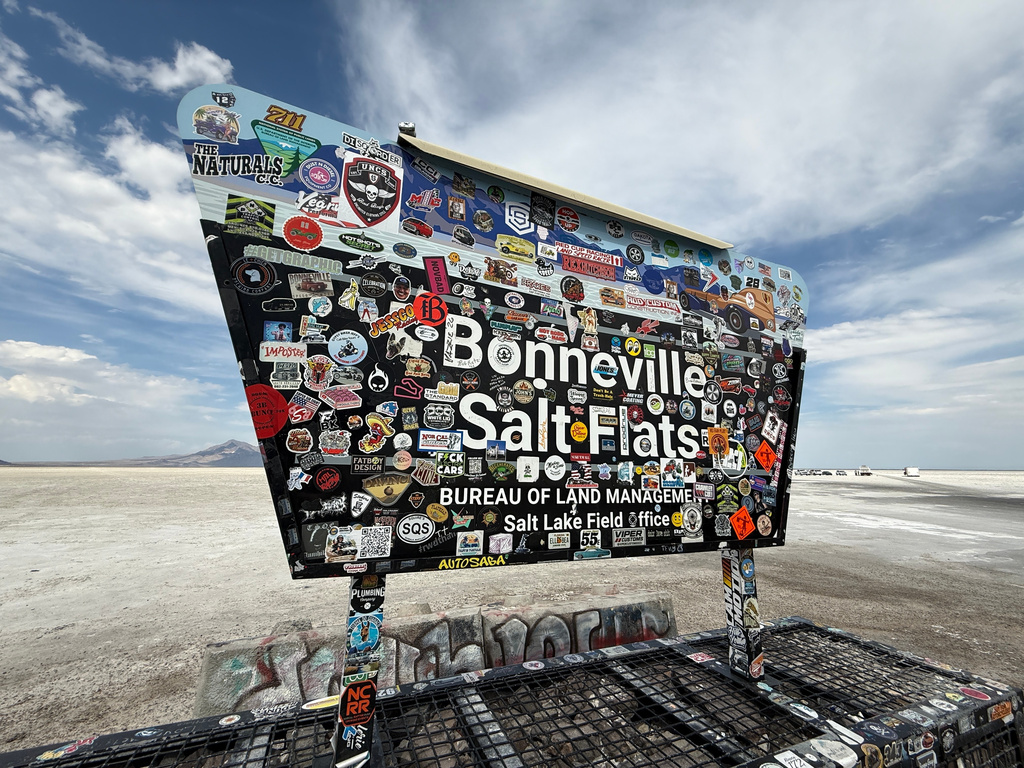 Racing stickers cover a sign for Utah’s Bonneville Salt Flats, home to a speedway where several land speed records have been set, Monday, Aug. 10, 2026. (AP Photo/Hannah Schoenbaum)