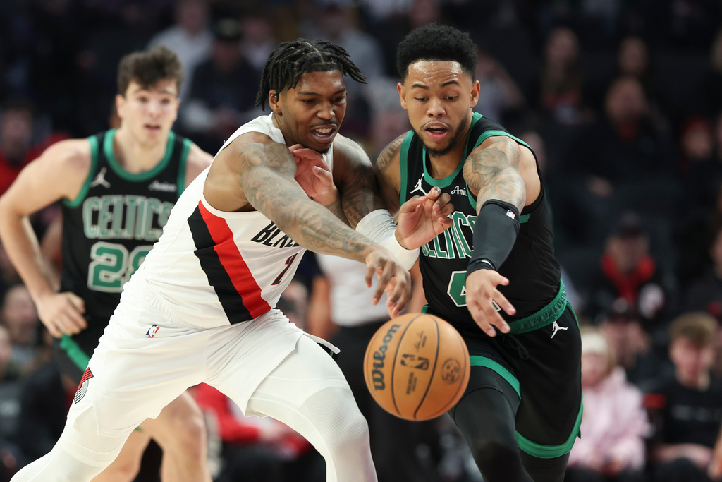 Portland Trail Blazers guard Caleb Love (2) and Boston Celtics guard Anfernee, right, Simons battle for a loose ball during the first half of an NBA basketball game, Sunday, Dec. 28, 2025, in Portland, Ore. (AP Photo/Amanda Loman)
