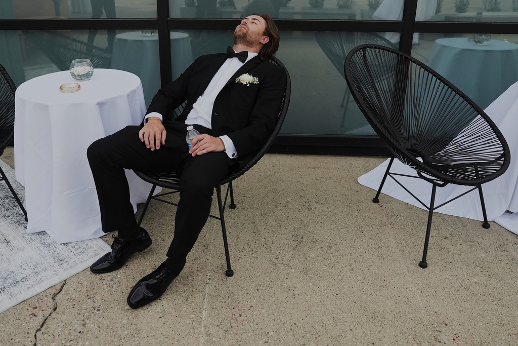 FILE - A Groomsman takes a break after finishing bridal party photos at a wedding on Saturday, Aug. 23, 2025, in Newtown, Ohio. (AP Photo/Joshua A. Bickel, File)
