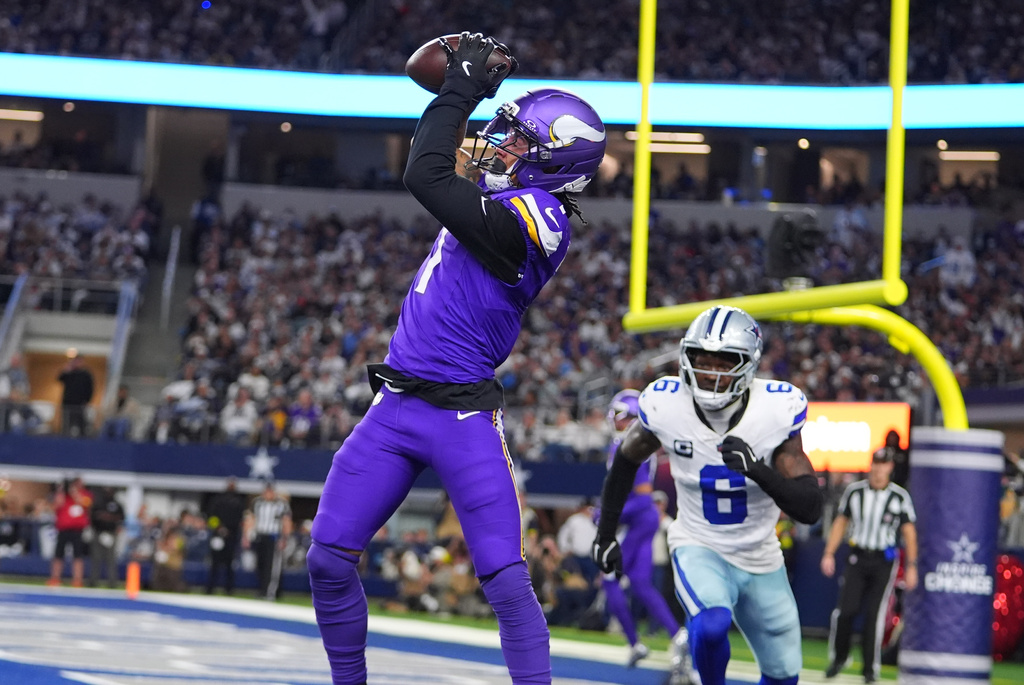Minnesota Vikings wide receiver Jalen Nailor hauls in a touchdown catch in the end zone as Dallas Cowboys safety Donovan Wilson defends during the second half of an NFL football game Sunday, Dec. 14, 2025, in Arlington, Texas. (AP Photo/Julio Cortez)