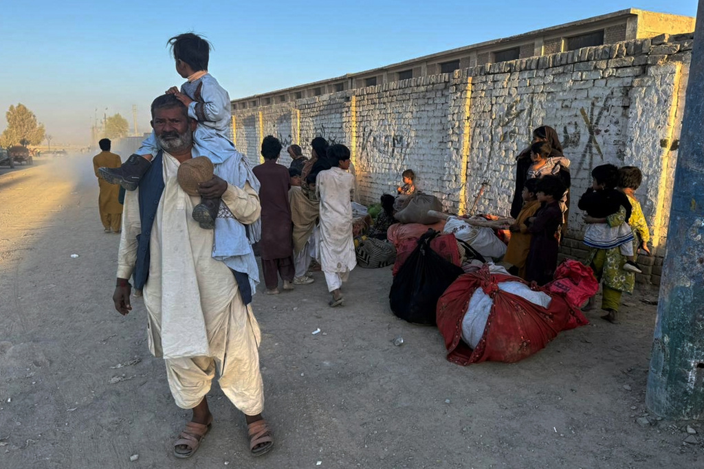 Local residents, who fled their homes following border clashes between Pakistan and Afghan forces, wait for transportation in Chaman, a town on the Pakistan side of the Afghanistan border, Wednesday, Oct. 15, 2025. (AP Photo/H. Achakzai)
