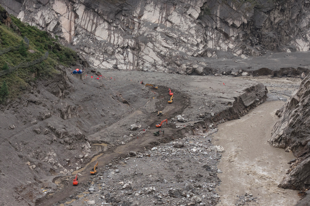 In this photo released by Xinhua News Agency, rescuers use excavators to clear a road at the core area of the mudslide-hit Gyirong Port in Gyirong County, southwestern China's Tibet Autonomous Region, Wednesday, Sept. 2, 2026. (Tenzing Nima Qadhup/Xinhua via AP)