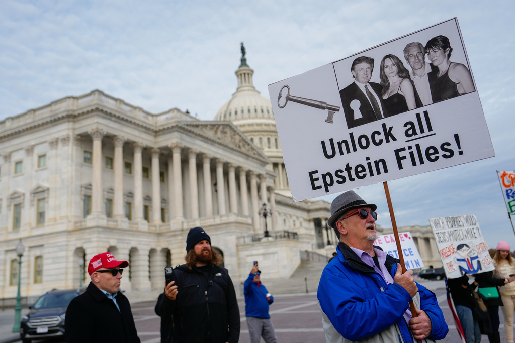 Protesters hold signs during a news conference on the Epstein Files Transparency Act, Tuesday, Nov. 18, 2025, outside the U.S. Capitol in Washington. (AP Photo/Julia Demaree Nikhinson)