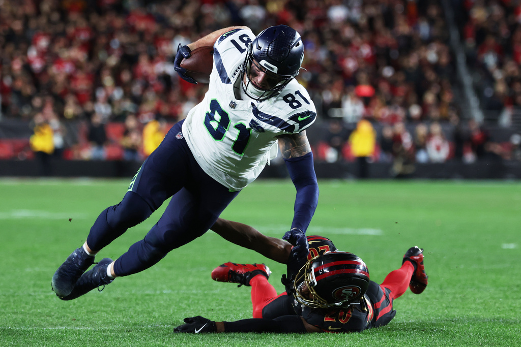 Seattle Seahawks tight end Eric Saubert (81) is tackled by San Francisco 49ers cornerback Upton Stout during the second half of an NFL football game in Santa Clara, Calif., Saturday, Jan. 3, 2026. (AP Photo/Jed Jacobsohn)