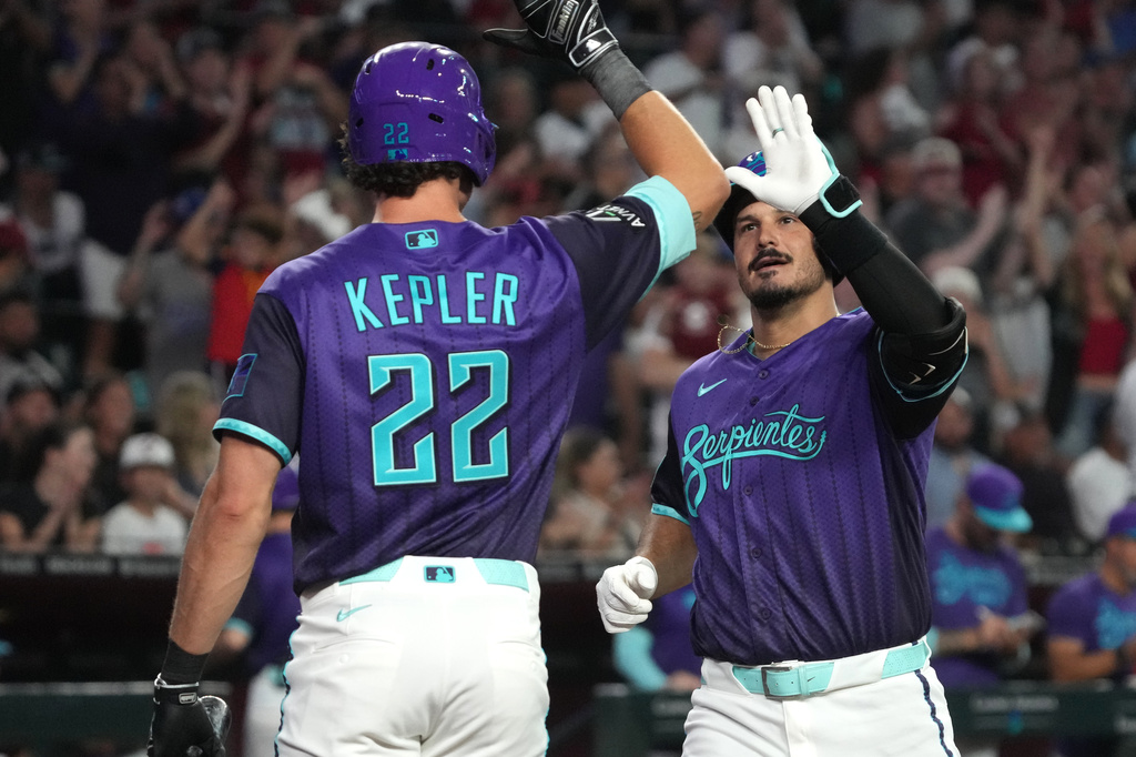 Arizona Diamondbacks' Nolan Arenado, right, celebrates with Max Kepler (22) after hitting a solo home run against the Los Angeles Dodgers in the second inning of a baseball game, Friday, Aug 7, 2026, in Phoenix. (AP Photo/Rick Scuteri)