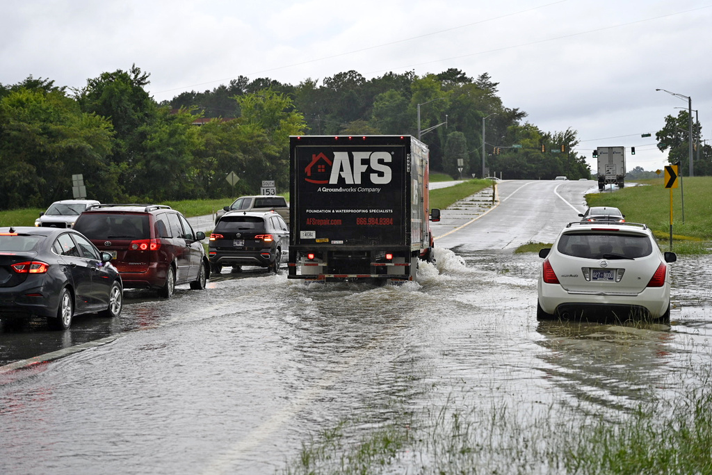 Traffic moves slowly through floodwaters on Bonny Oaks Drive, in Chattanooga, Tenn., on Aug. 12, 2025. (Mason Edwards/Chattanooga Times Free Press via AP)