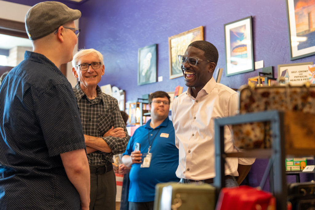 David Crowley, right, Democratic candidate for Wisconsin governor talks with CJ Arthur, left, owner of WordHaven BookHouse during a campaign stop with Wisconsin Gov. Tony Ever, center, Friday, Aug. 7, 2026, in Sheboygan, Wis. (AP Photo/Kayla Wolf)