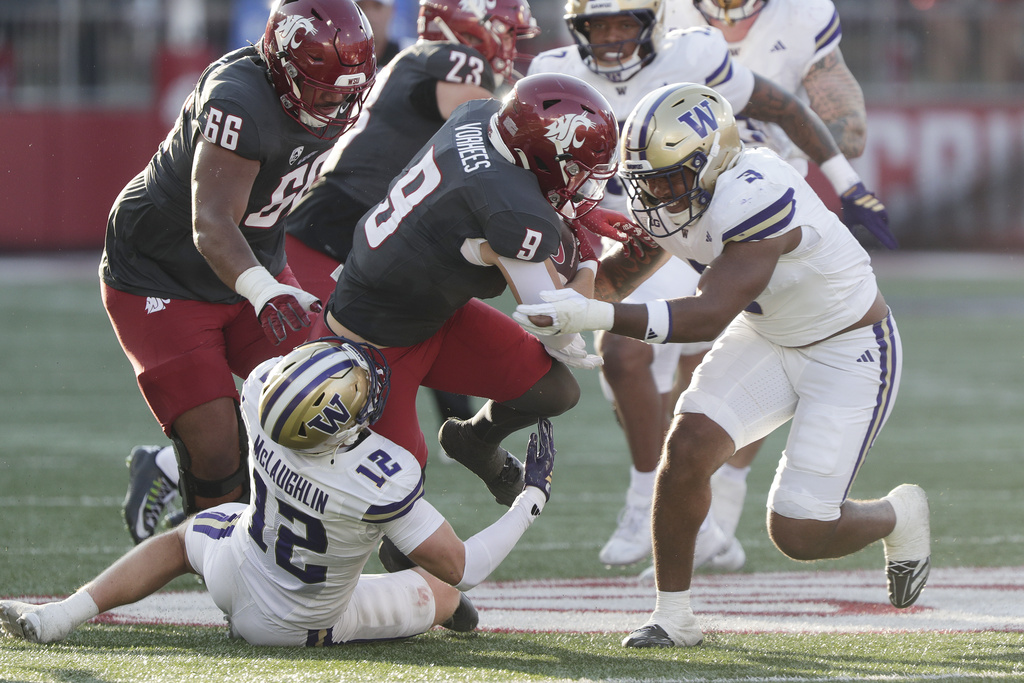 Washington safety Alex McLaughlin (12) and linebacker Buddah Al-Uqdah (3) tackle Washington State running back Kirby Vorhees (9) during the first half of an NCAA college football game, Saturday, Sept. 20, 2025, in Pullman, Wash. (AP Photo/Young Kwak)