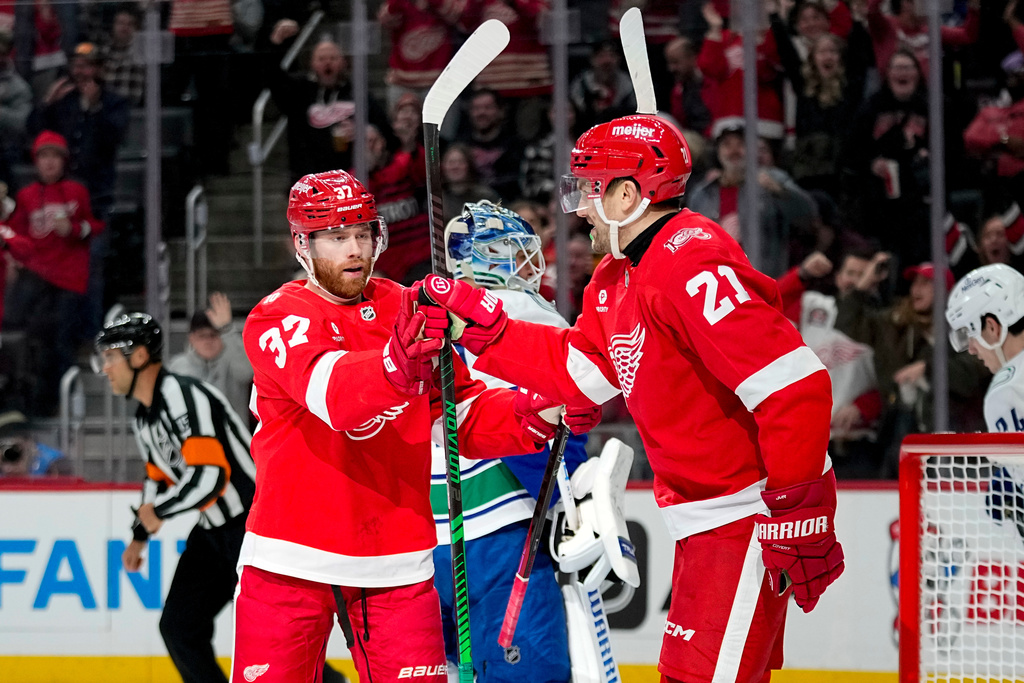 Detroit Red Wings left wing J.T. Compher, left, celebrates with left wing James van Riemsdyk, right, after scoring during the second period of an NHL hockey game against the Vancouver Canucks, Thursday, Jan. 8, 2026, in Detroit. (AP Photo/Ryan Sun)