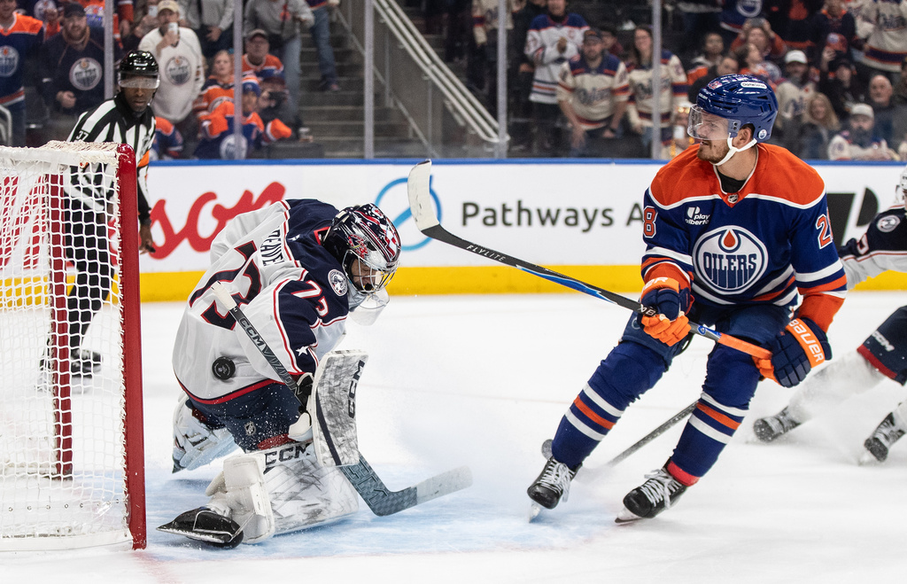 Columbus Blue Jackets' goalie Jet Greaves (73) is scored against by Edmonton Oilers' Jack Roslovic (28) during overtime NHL hockey game action, in Edmonton, Alberta, Monday, Nov. 10, 2025. (Jason Franson/The Canadian Press via AP)