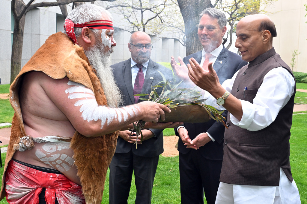 India's Defence Minister Rajnath Singh, right, participates in an indigenous smoking ceremony with his Australian counterpart Richard Marles, second right, at Parliament House in Canberra, Australia, Thursday, Oct. 9, 2025. (Mick Tsikas/AAP Image via AP)