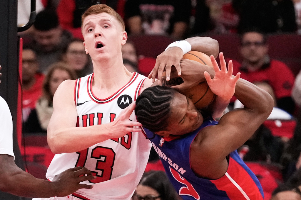Chicago Bulls guard/forward Kevin Huerter, left, and Detroit Pistons guard/forward Ausar Thompson battle for a loose ball during the first half of an NBA basketball game in Chicago, Wednesday, Oct. 22, 2025. (AP Photo/Nam Y. Huh)