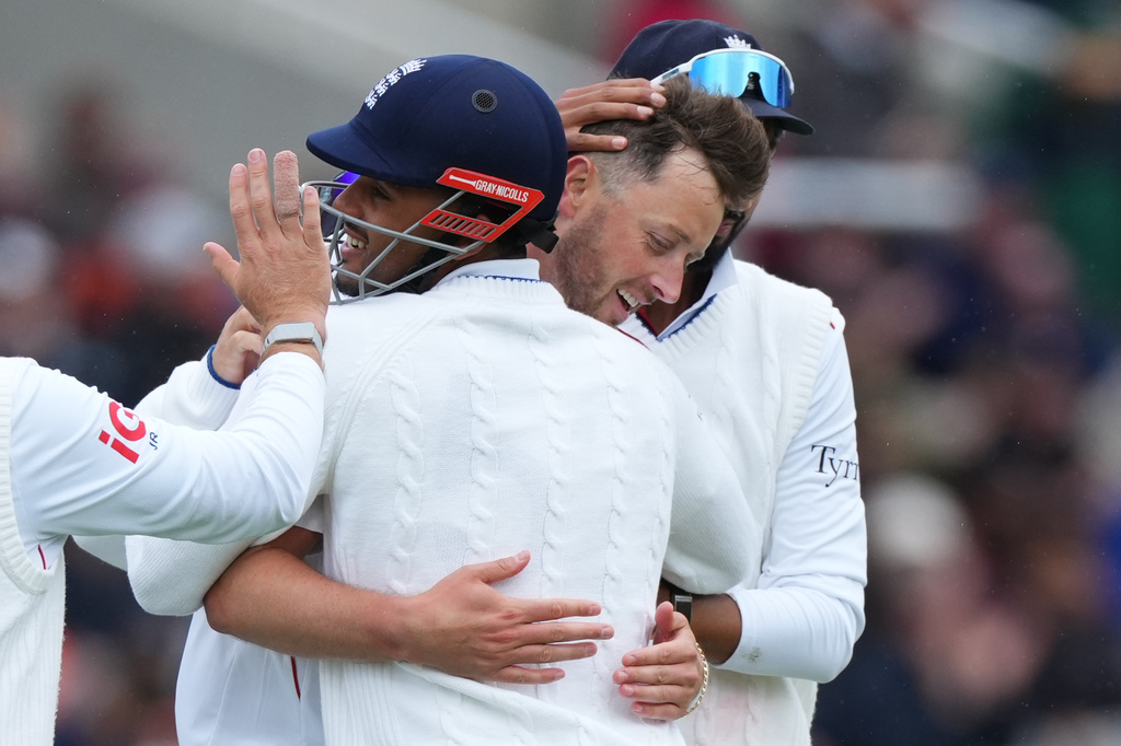 England's Ollie Robinson, center, celebrates with teammates after the dismissal of New Zealand's Rachin Ravindra during the third day of the Test match between England and New Zealand at Lord's cricket ground in London, Saturday, June 6, 2026. (AP Photo/Kirsty Wigglesworth)