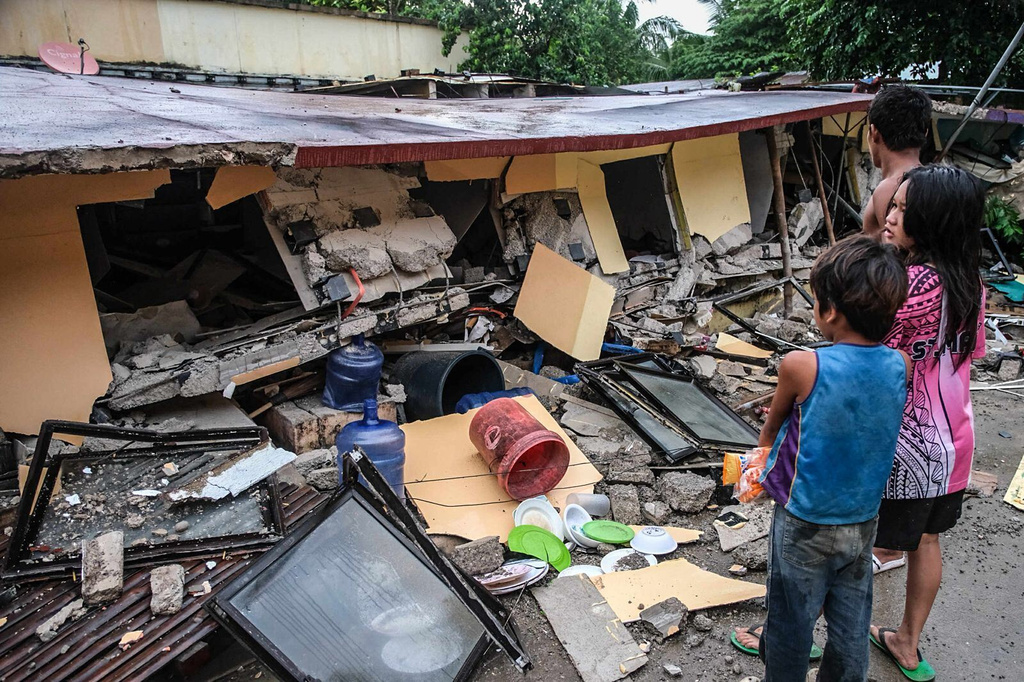 People look at a collapsed building in Bogo City, Cebu province, Philippines Wednesday, Oct. 1, 2025 after an offshore earthquake on late Tuesday. (AP Photo)