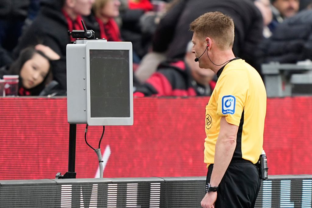 Referee Christian Dingert watches the VAR during a German Bundesliga soccer match between Bayer Leverkusen and Bayern Munich in Leverkusen, Germany, Saturday, March 14, 2026. (AP Photo/Martin Meissner)