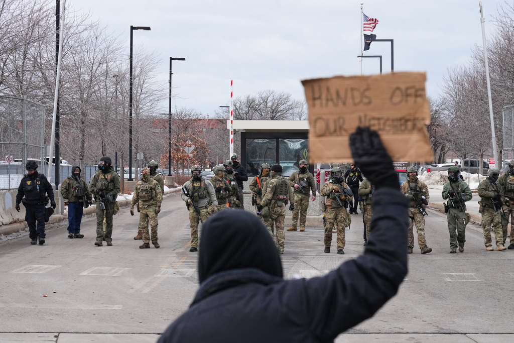 Protesters confront federal immigration officers outside the Bishop Henry Whipple Federal Building, Tuesday, Jan. 13, 2026, in Minneapolis. (AP Photo/Adam Gray)