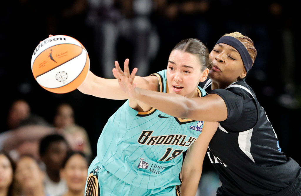 New York Liberty guard Pauline Astier, left, and Las Vegas Aces forward NaLyssa Smith fight for the ball during the first half of an WNBA basketball game Tuesday, June 23, 2026, in Las Vegas. (Steve Marcus/Las Vegas Sun via AP)