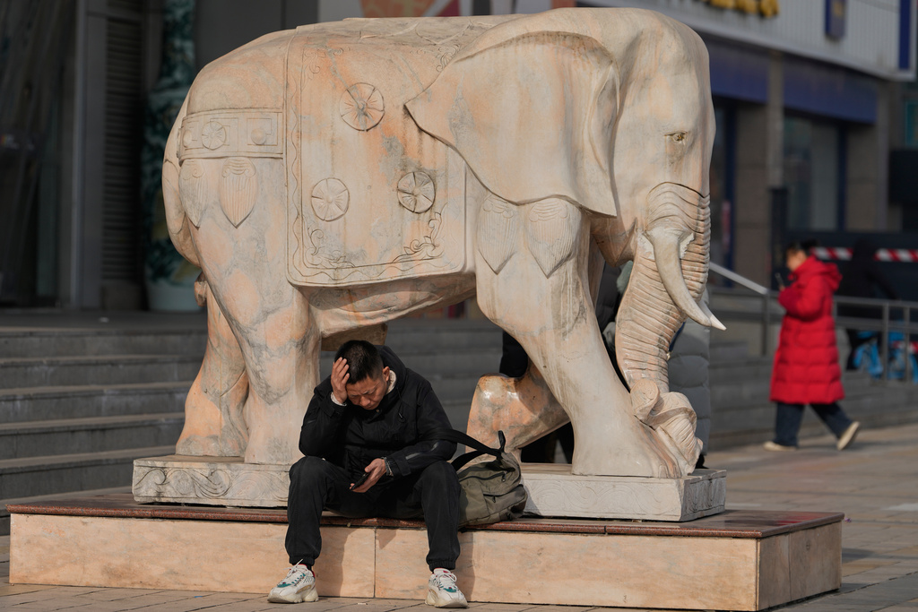 A man reacts while holding his smartphone in Beijing, China, Thursday, Jan. 15, 2026. (AP Photo/Ng Han Guan)