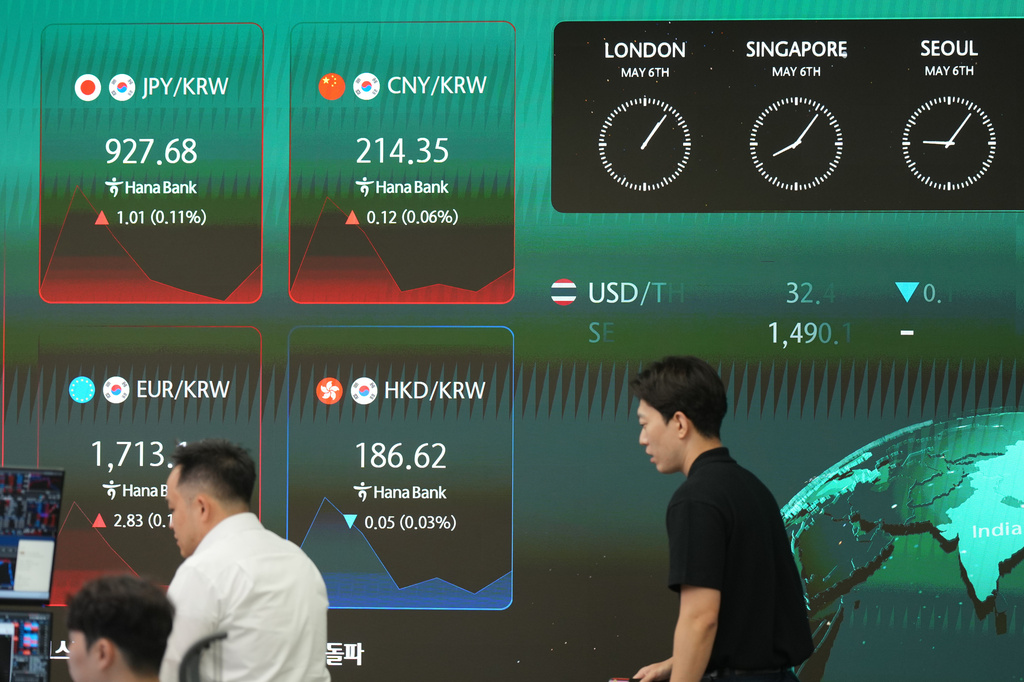 Dealers walk past near the screens showing the foreign exchange rates at a dealing room of Hana Bank in Seoul, South Korea, Wednesday, May 6, 2026. (AP Photo/Lee Jin-man)