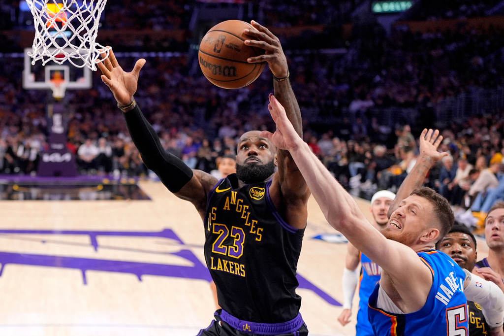Los Angeles Lakers forward LeBron James, left, grabs a rebound away from Oklahoma City Thunder center Isaiah Hartenstein during the first half of Game 4 in a second-round NBA basketball playoffs series Monday, May 11, 2026, in Los Angeles. (AP Photo/Mark J. Terrill)