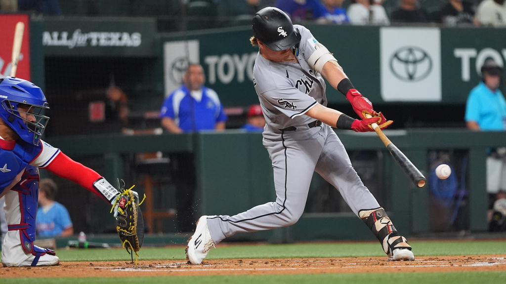 Chicago White Sox's Chase Meidroth, right, hits a run scoring single in front of Texas Rangers catcher Elias Díaz during the second inning of a baseball game, Wednesday, July 22, 2026, in Arlington, Texas. (AP Photo/LM Otero)