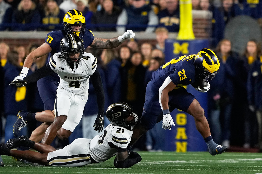 Michigan running back Jordan Marshall (23) is tackled by Purdue defensive back Tahj Ra-El (21) during the first half of an NCAA college football game, Saturday, Nov. 1, 2025, in Ann Arbor, Mich. (AP Photo/Ryan Sun)
