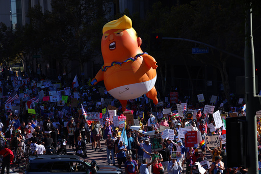 Pulling a giant inflatable Donald Trump protesters march in the streets during a "No Kings" protest Saturday, Oct. 18, 2025, in Los Angeles. (AP Photo/Ethan Swope) Pulling a giant inflatable Donald Trump protesters march in the streets during a "No Kings" protest Saturday, Oct. 18, 2025, in Los Angeles. (AP Photo/Ethan Swope)