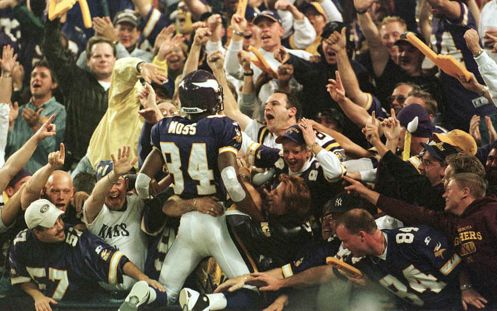 FILE - Minnesota Vikings wide receiver Randy Moss (84) jumps into the crowd to celebrate his 42-yard touchdown pass from Daunte Culpepper during the fourth quarter of an NFL football game against the Tampa Bay Buccaneers, in Minneapolis, Oct. 9, 2000. (AP Photo/Paul Battaglia, File)