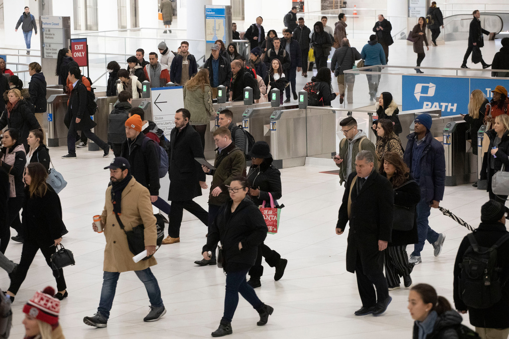 FILE - Commuters walk from the PATH rapid transit station into the World Trade Center in New York on Nov. 18, 2019. (AP Photo/Mark Lennihan, File)