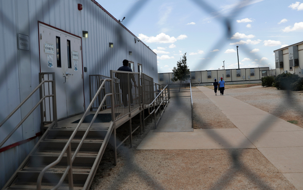 FILE - Immigrants seeking asylum walk at the ICE South Texas Family Residential Center, Aug. 23, 2019, in Dilley, Texas. (AP Photo/Eric Gay, File)